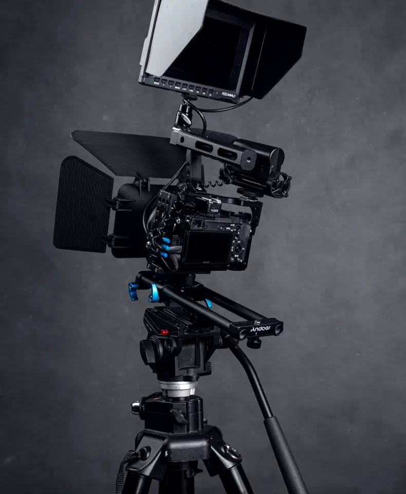 Two cameras on tripods set up for a side-by-side comparison against a grey card
